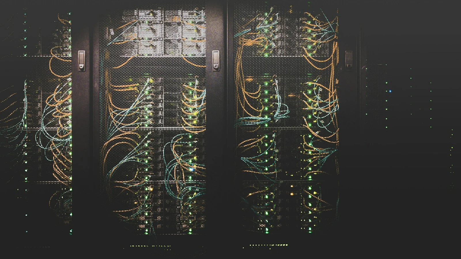 Enclosed racks with equipment and network cabling in a data center.
