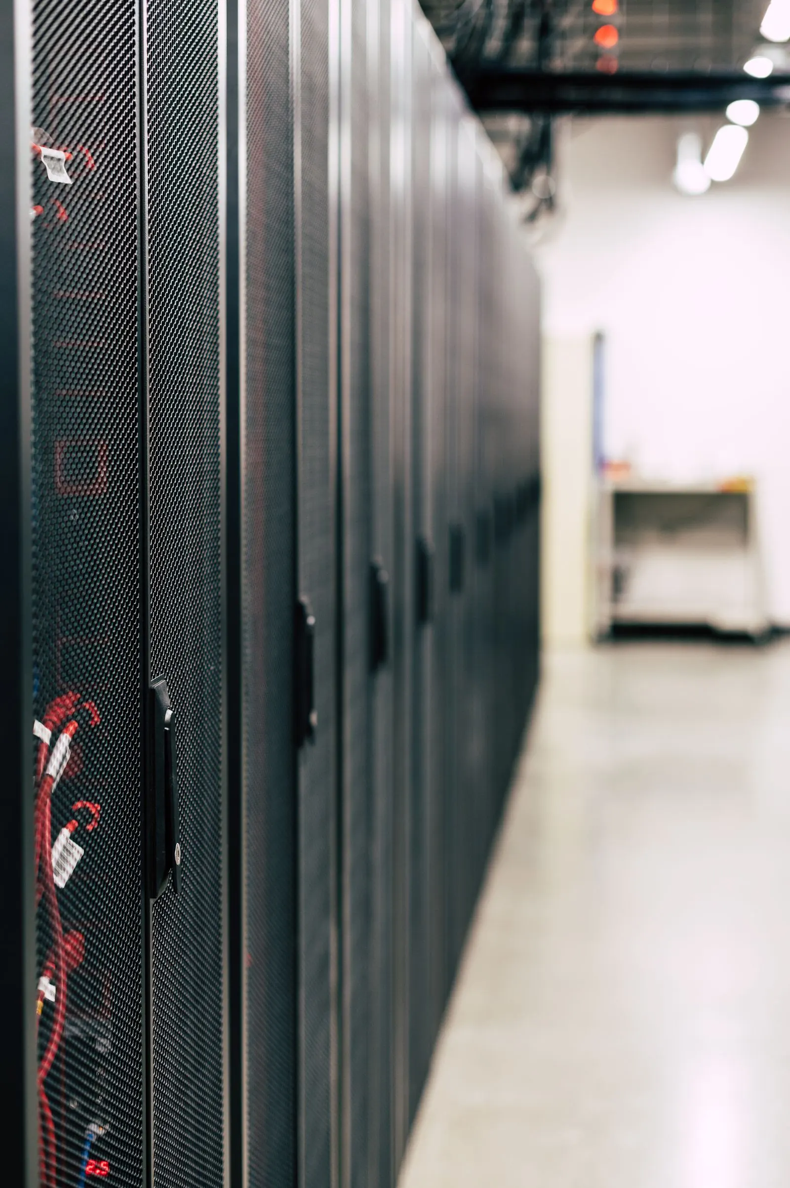 Aisle with organized enclosed server racks in a data center.