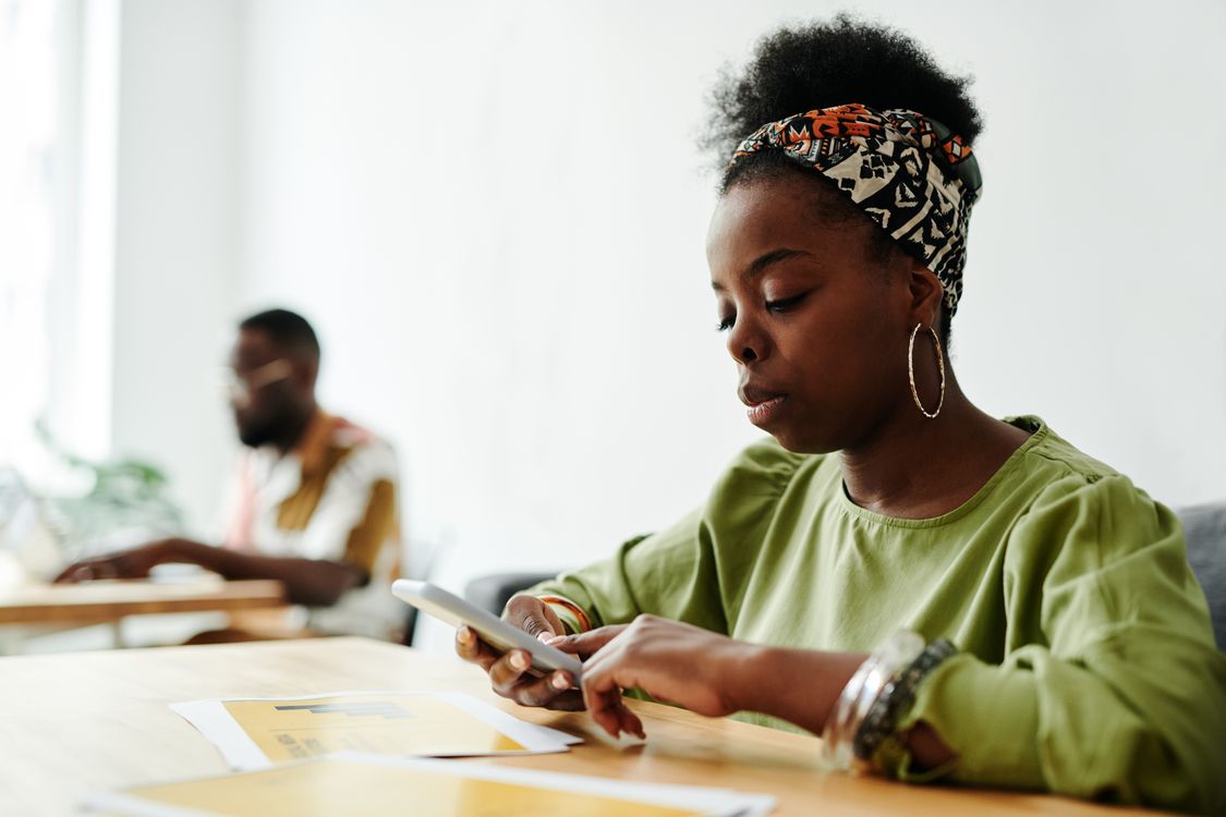 A professional using a phone in a shared workspace.