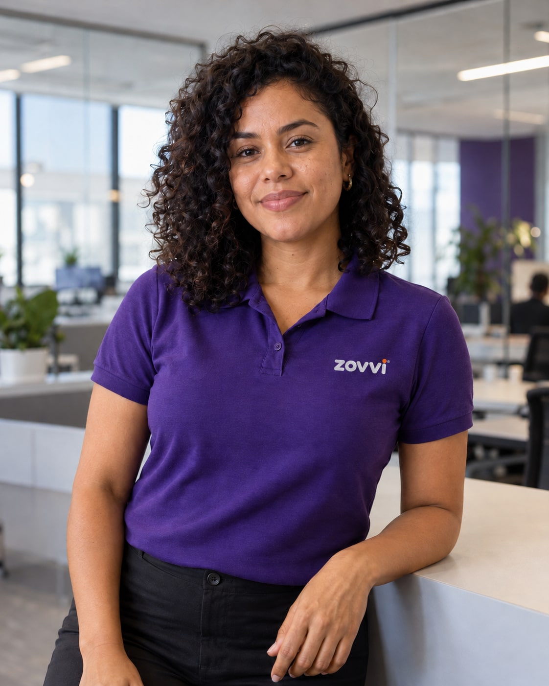 Professional in a purple polo with a small embroidered Zovvi mark, in a contemporary office.
