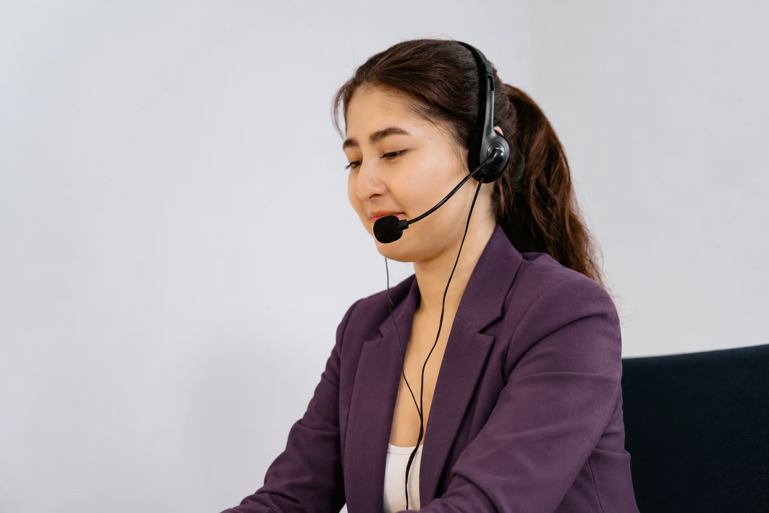 Profesional de atención escuchando una conversación con auriculares