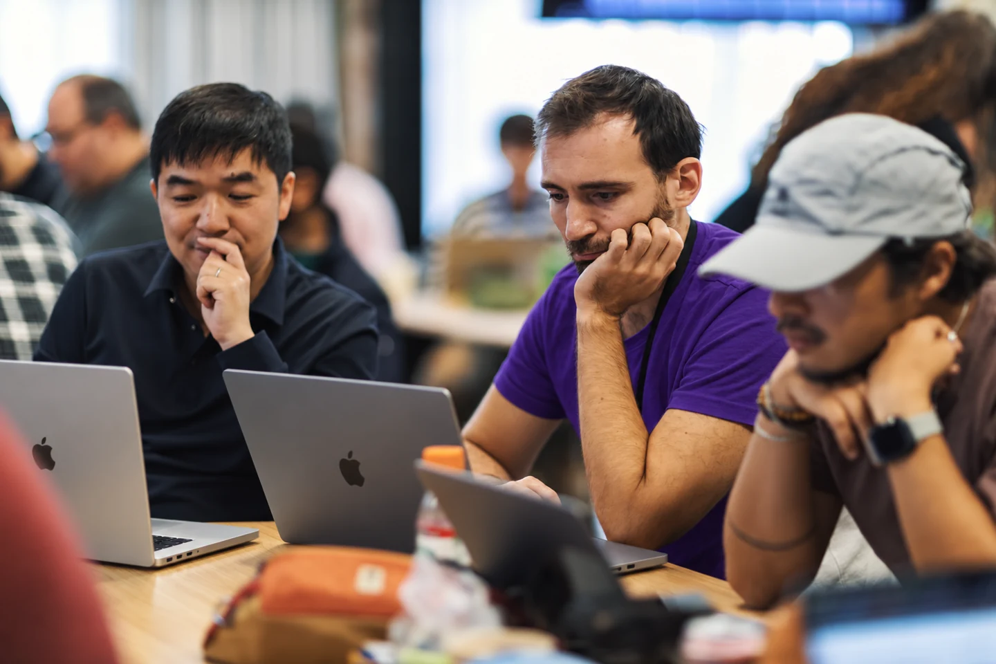 Professionals working on projects with MacBooks in a shared workspace