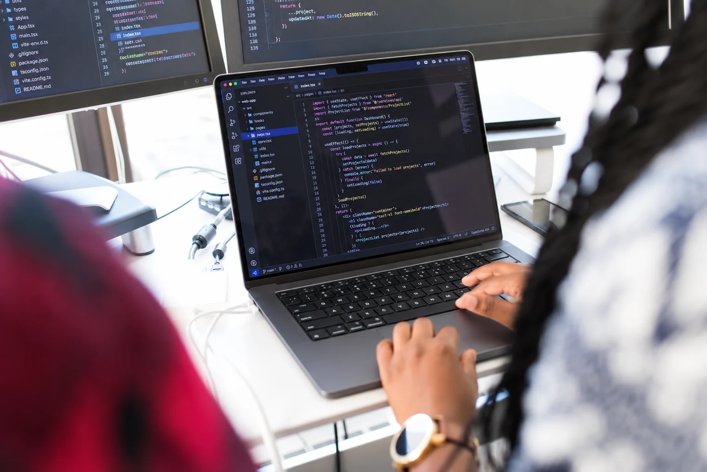 Professional developing an application on a MacBook with a code editor